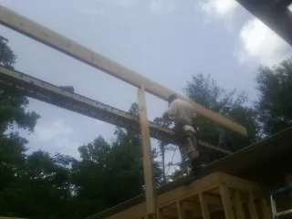Carpenter setting a ridge beam over a new addition frame — Ice Dam Removal by Roofing Brothers in Mattoon