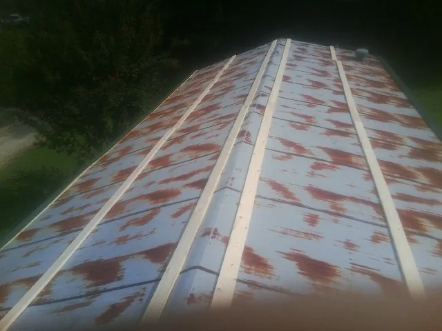 Rusted metal roof panels with new wood purlins before replacement — Storm Damage Roof Repair in Mattoon by Roofing Brothers