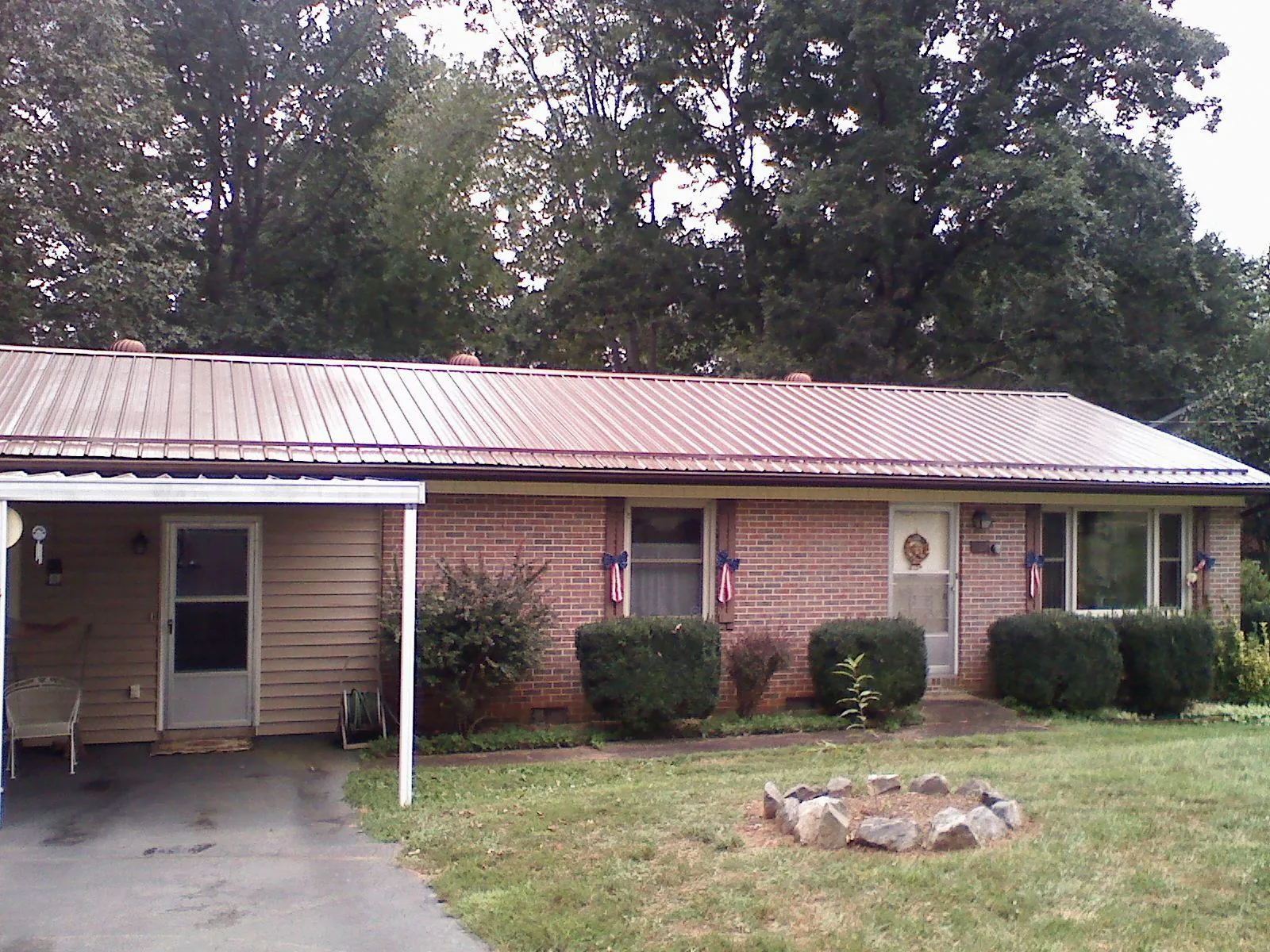 Bronze metal roof and carport on a brick ranch home — Roof Repair work by our crew in Mattoon